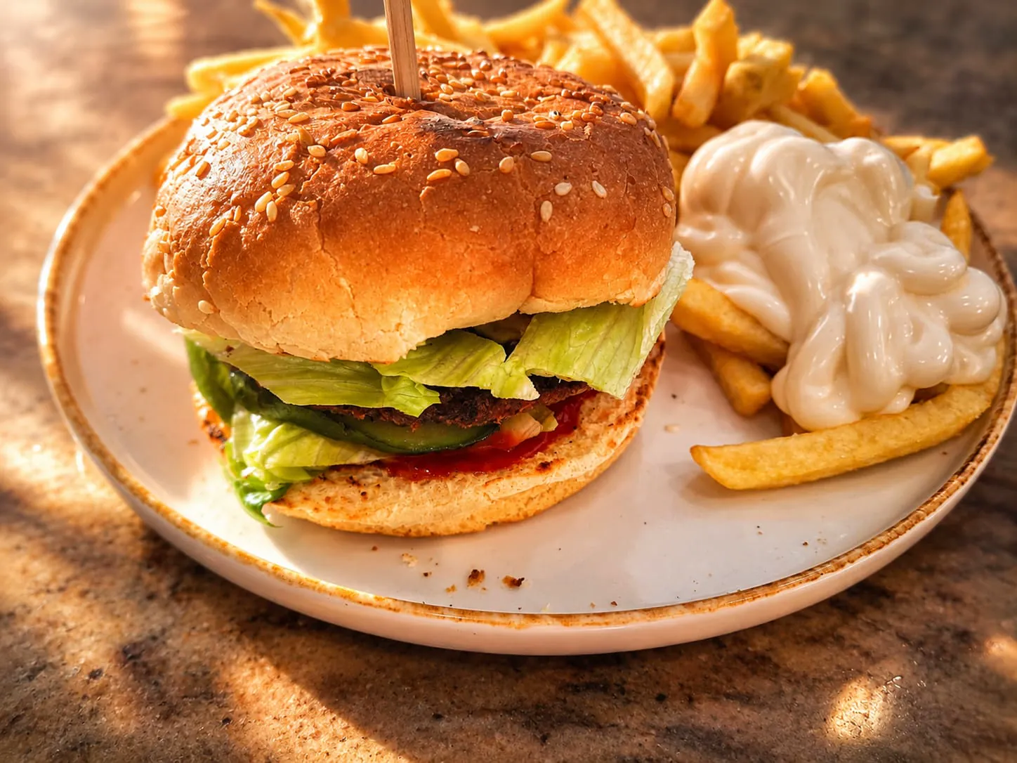 Burger mit Salat, dazu Pommes und Mayonnaise